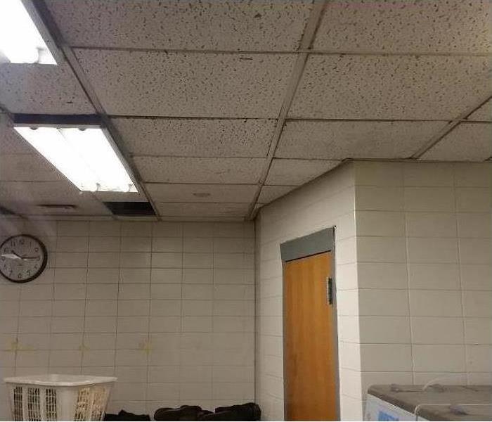 The water damage has cause the ceiling tiles to swell up and come out of place.